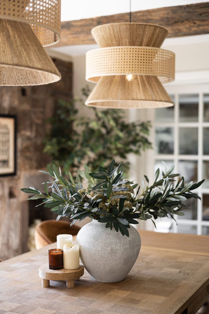 modern farmhouse kitchen with white cabinets, wooden beams, and pendant lights.