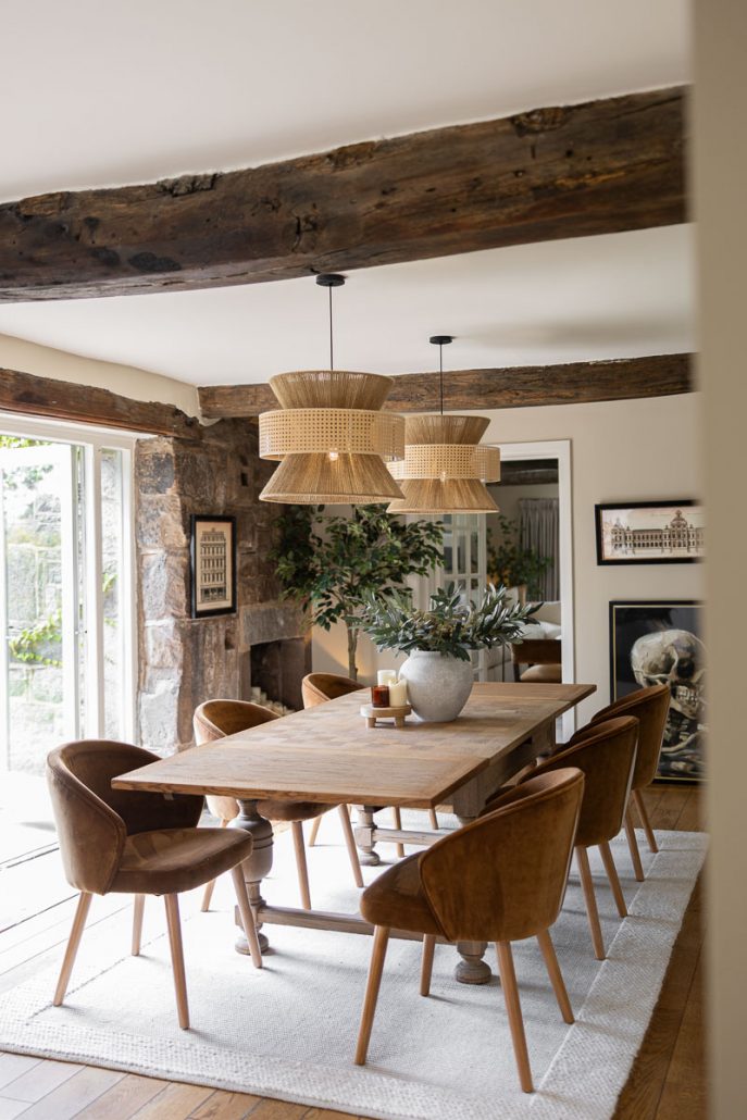 modern farmhouse kitchen with white cabinets, wooden beams, and pendant lights.