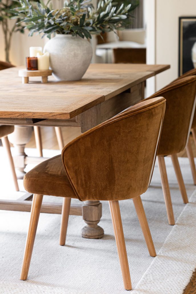 close-up of soft brown velvet chair and wooden table.