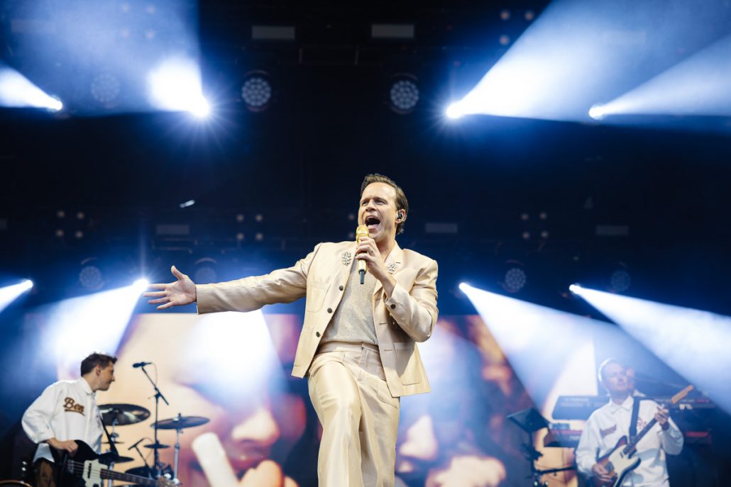 Olly Murs performing live on stage at Cartmel Racecourse concert with full band and lighting show