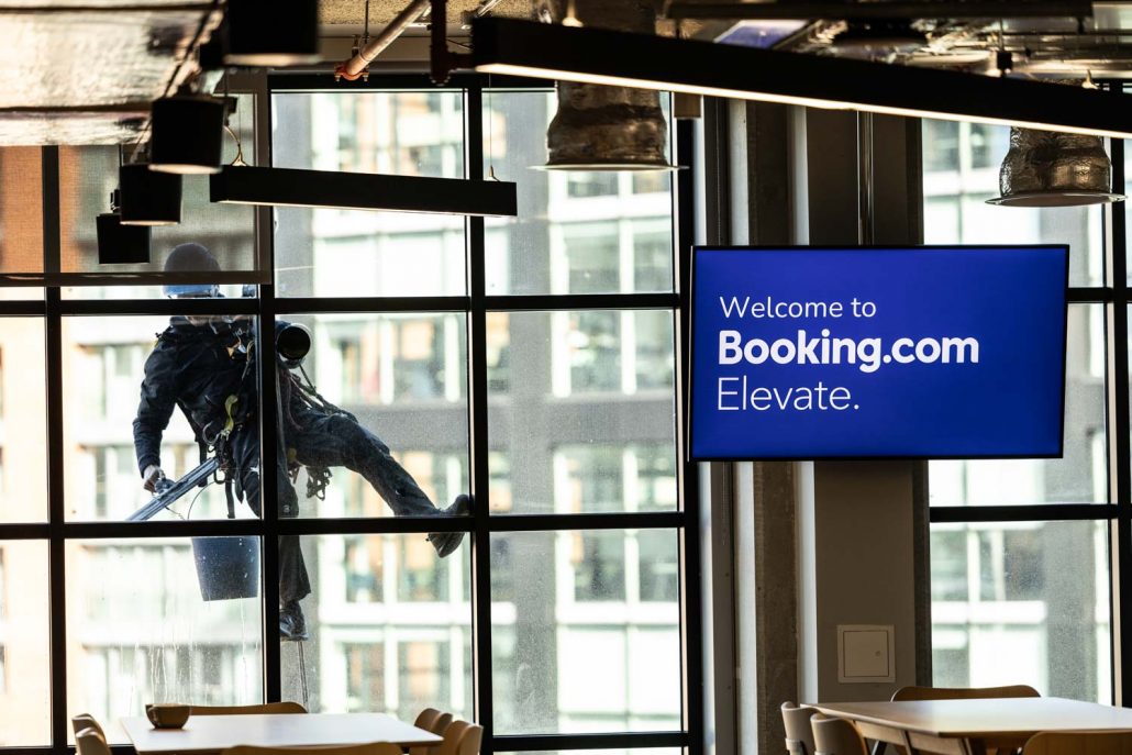 Guests networking and chatting in the Booking.com Manchester office café area during a corporate event.