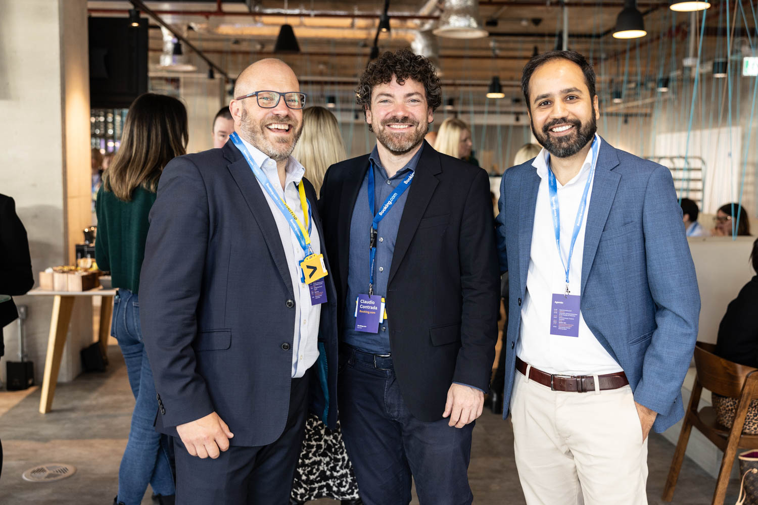 Guests networking and chatting in the Booking.com Manchester office café area during a corporate event.