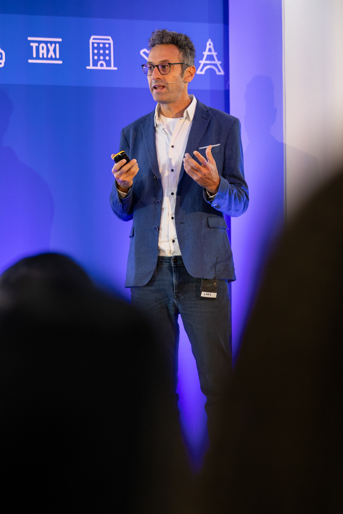 Speaker presenting on stage to a large audience during the Booking.com Elevate corporate event in Manchester