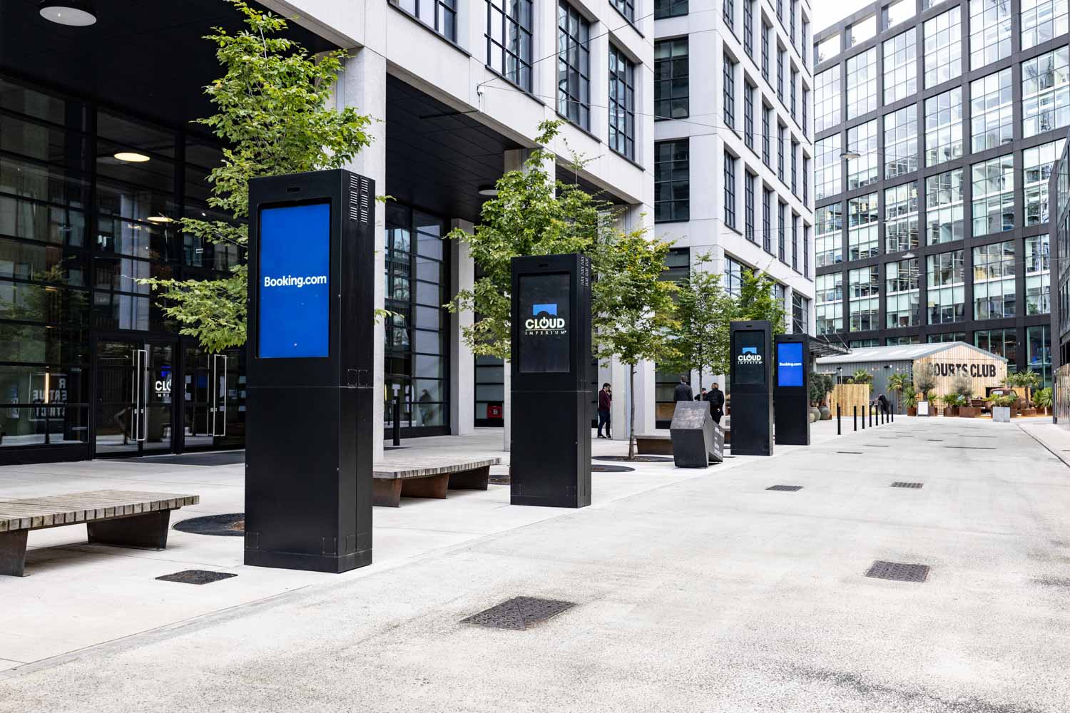 Guests networking and chatting in the Booking.com Manchester office café area during a corporate event.