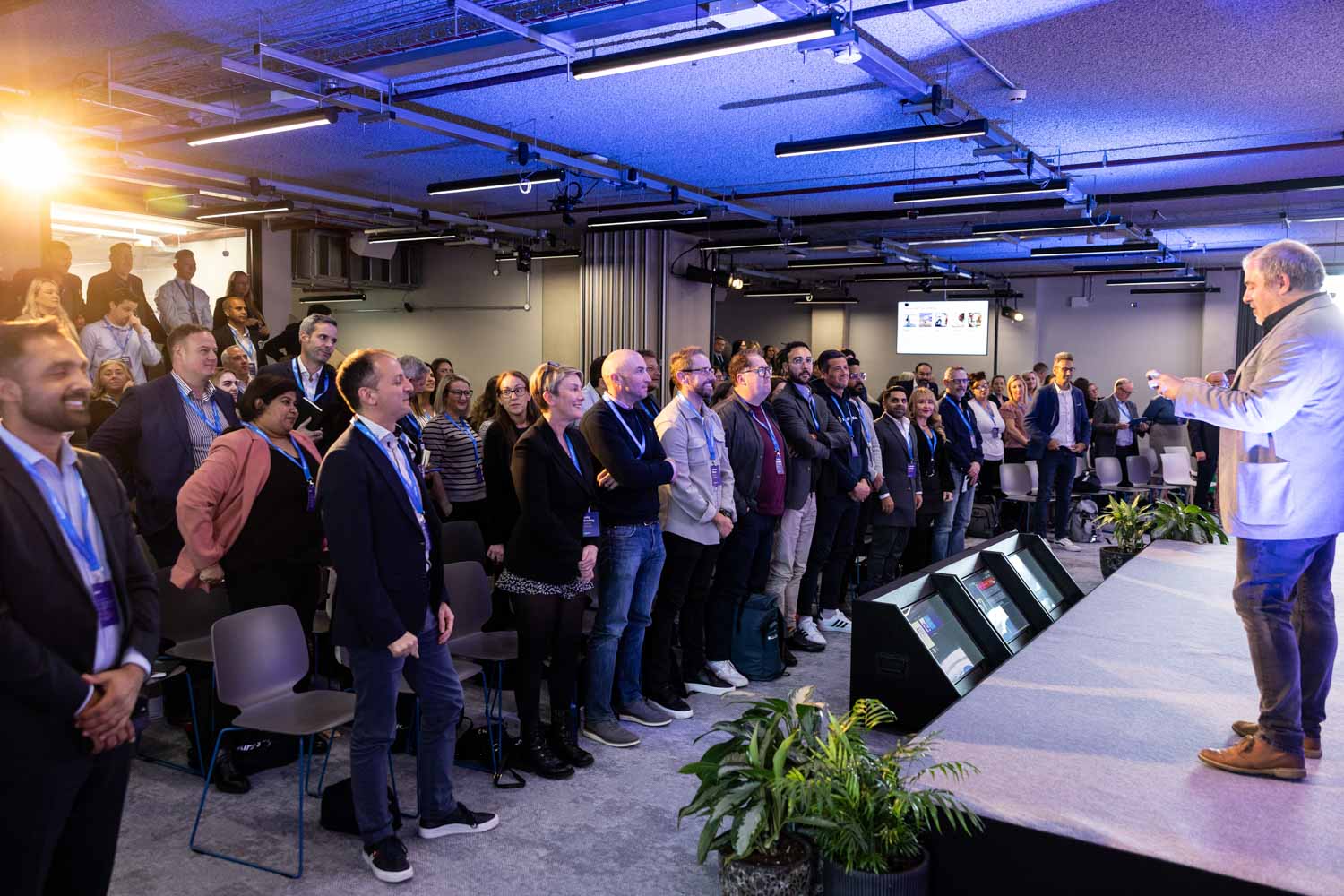 Speaker presenting on stage to a large audience during the Booking.com Elevate corporate event in Manchester