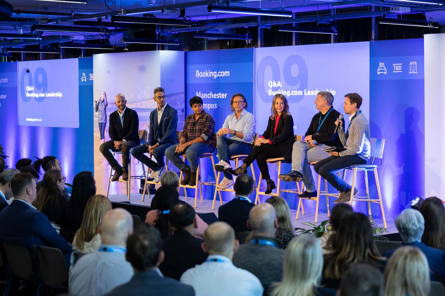 Speaker presenting on stage to a large audience during the Booking.com Elevate corporate event in Manchester