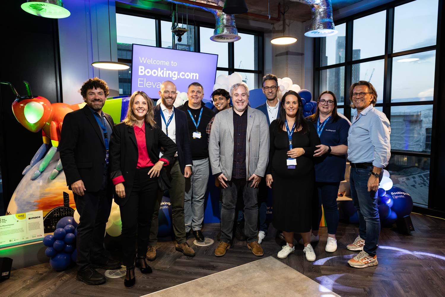 Booking.com team members celebrating together with a group photo at the Elevate event in Manchester.