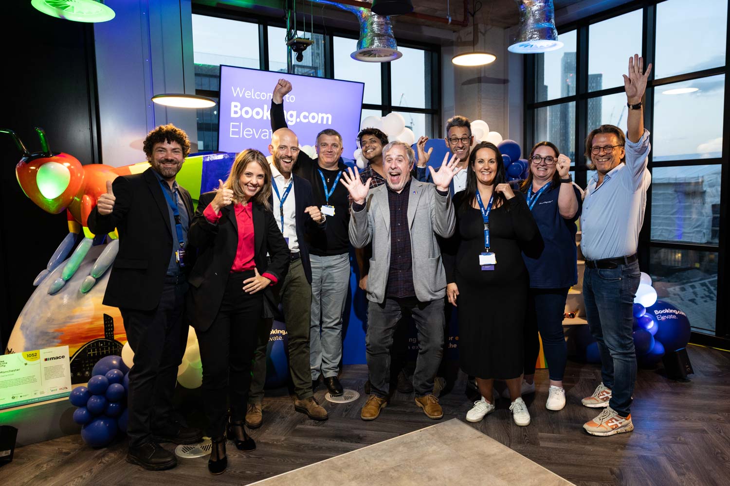 Booking.com team members celebrating together with a group photo at the Elevate event in Manchester.