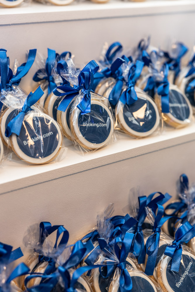 ndividually wrapped Booking.com branded cookies with blue ribbon displayed at a corporate event in Manchester
