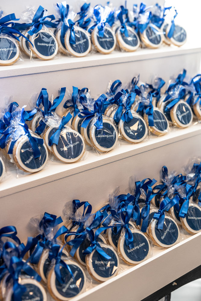 ndividually wrapped Booking.com branded cookies with blue ribbon displayed at a corporate event in Manchester