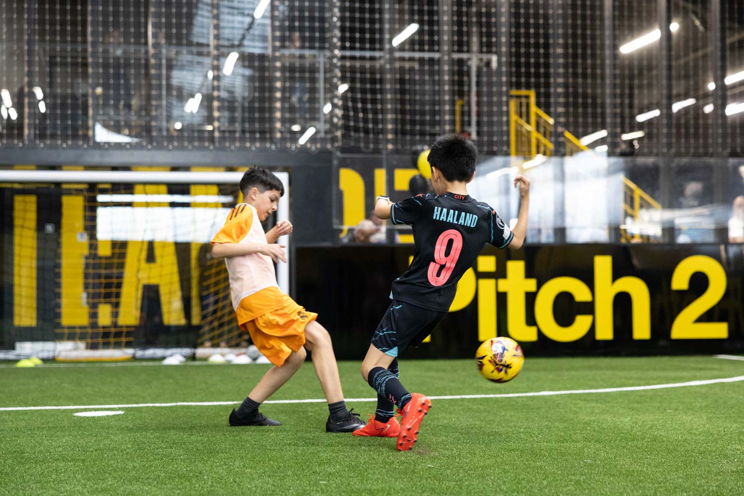 Kids playing football on indoor pitch at Pro Football Arena Stockport during launch event captured by Corporate Photographer Office Launch photographer