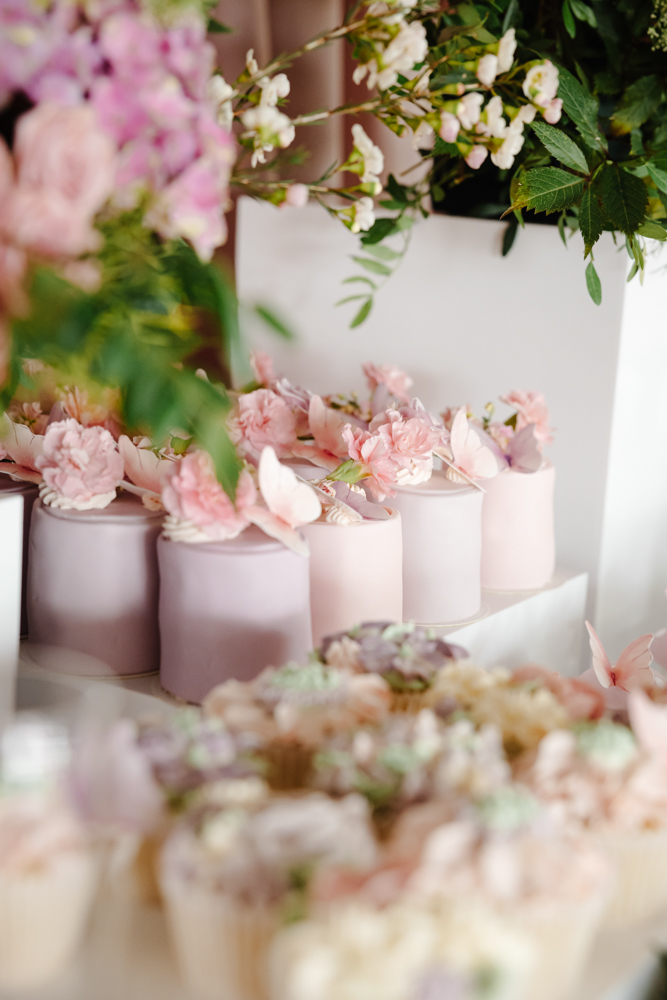 Long party table with personalised pink favour boxes and floral centrepieces at a luxury children’s birthday celebration