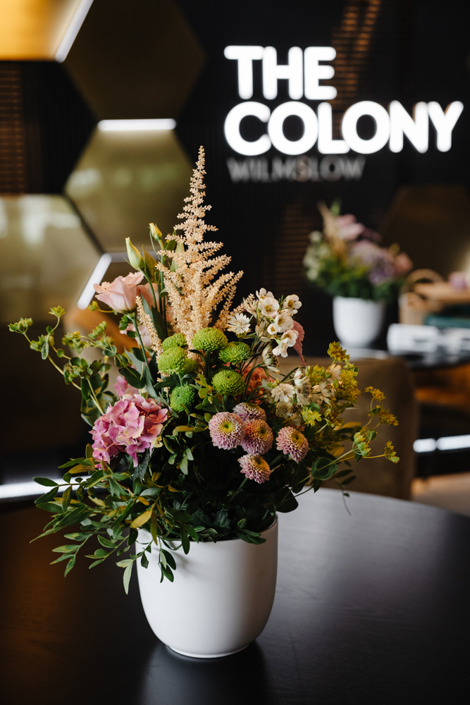 Close-up of pastel pink cakes and cupcakes decorated with flowers at an elegant birthday party setup