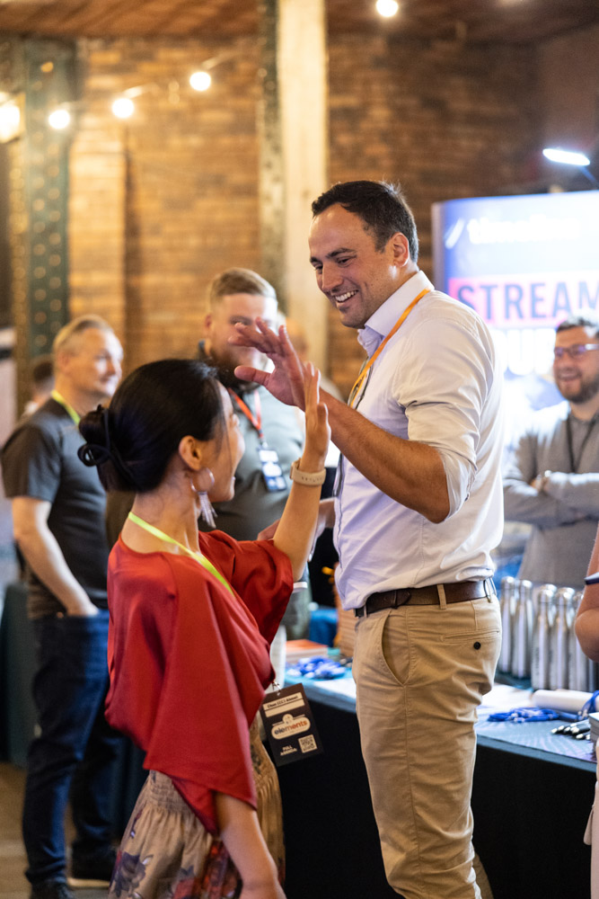 Attendees networking and high-fiving at corporate event in Manchester, Conference Photographer Manchester