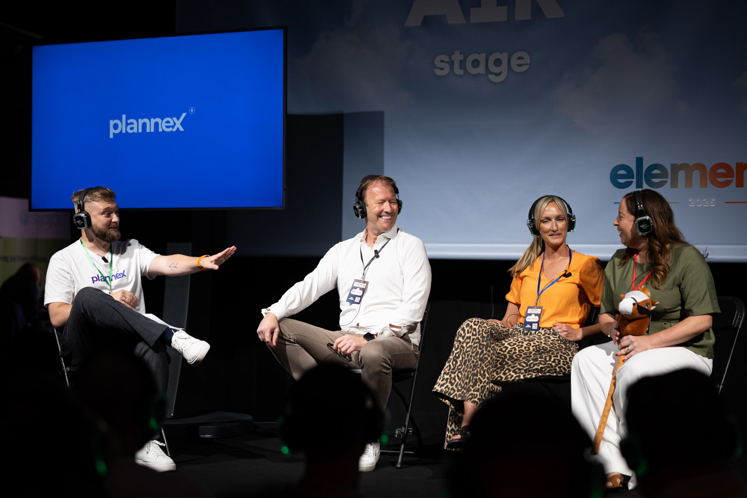 Panel discussion with multiple speakers wearing headphones on stage at Plannex Conference, Conference Photographer Manchester