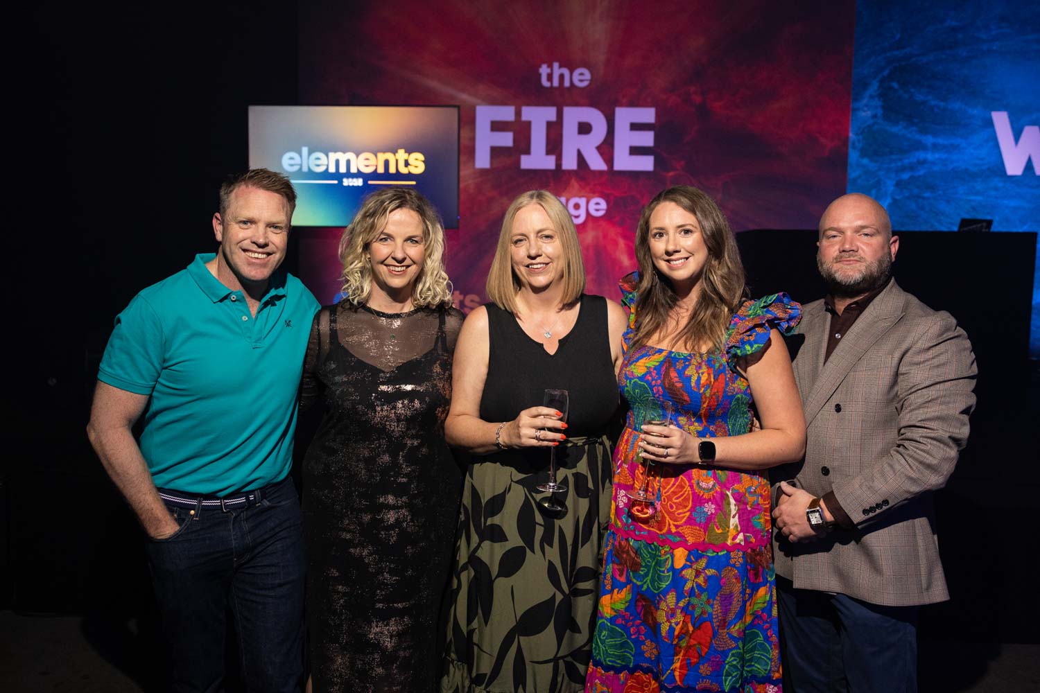 Conference Photographer Manchester capturing group portrait of guests at branded conference stage backdrop